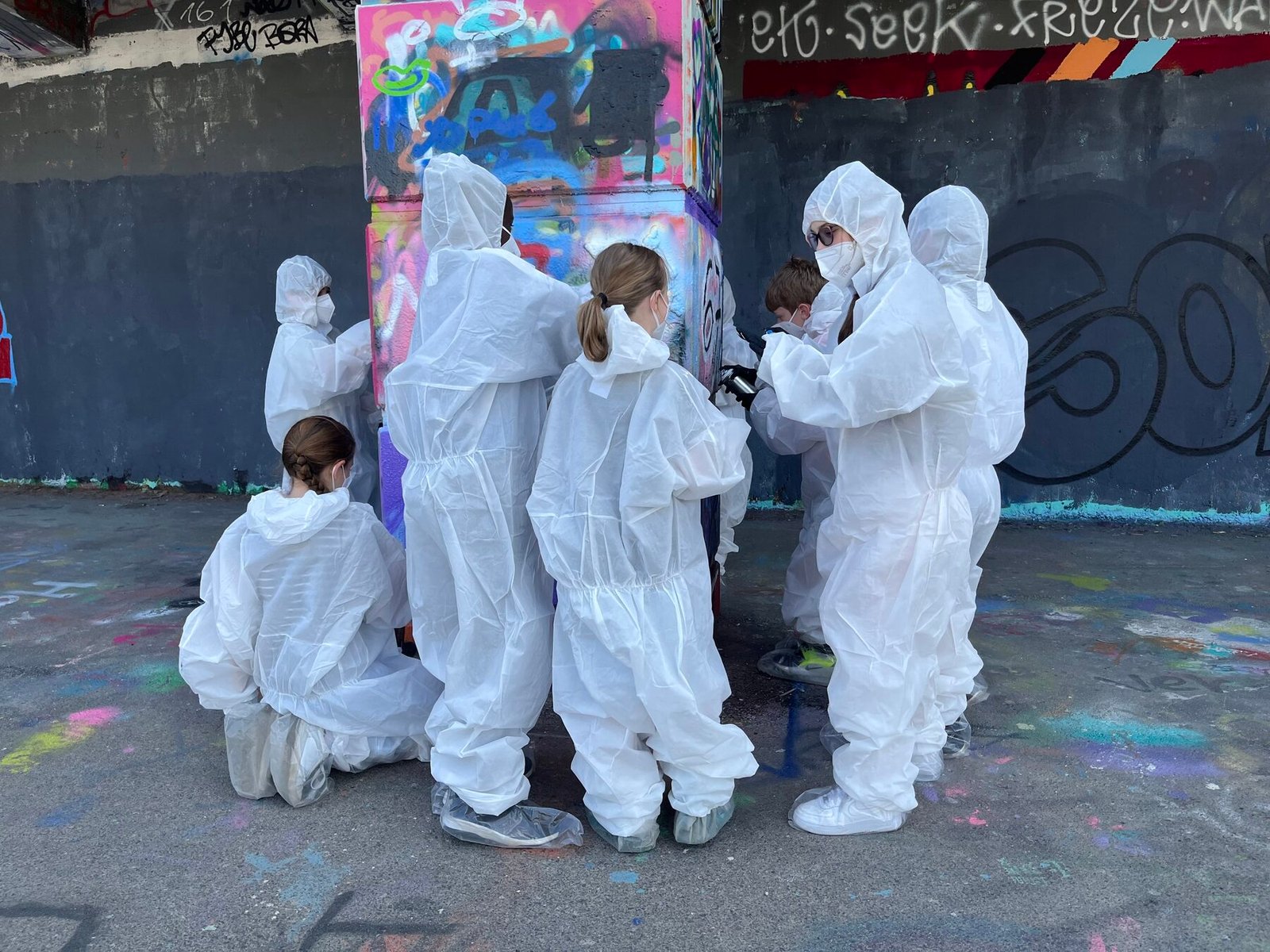 Workshop-Gruppe in weißen Schutzanzügen